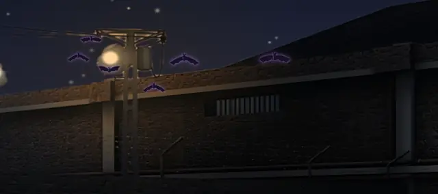 Una bandada de murciélagos cruza el cielo de noche sobre el muro del patio, junto a una torre de luz